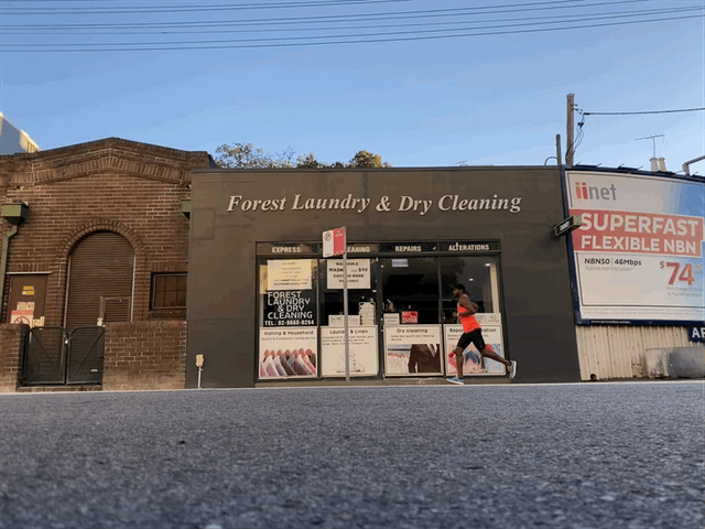 Daren running in front of a laundry and dry cleaning